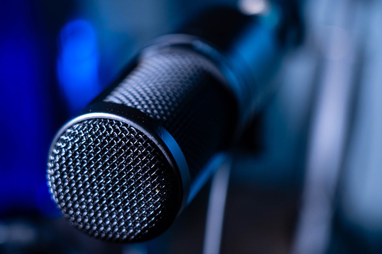 Detailed close-up of a professional studio microphone with a blurred blue background.